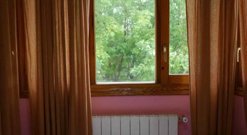 a room with a window and a radiator in front at Hostal El Alba in Brunete