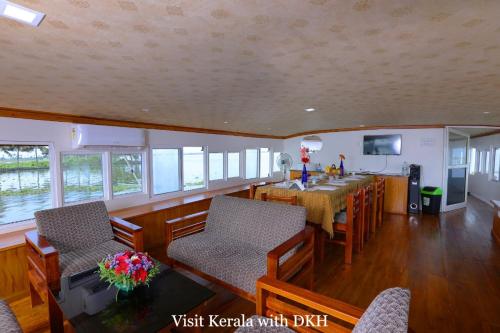 a dining room and kitchen with a table and chairs at Soma House Boat in Alleppey