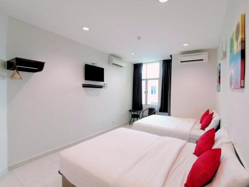 una camera d'albergo con due letti e una tv di HKF Hotel a Kajang