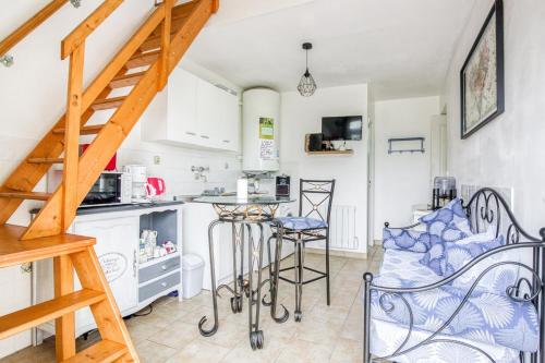 a kitchen and a living room with a spiral staircase at Gite Barbey in Sainte-Marie-du-Mont