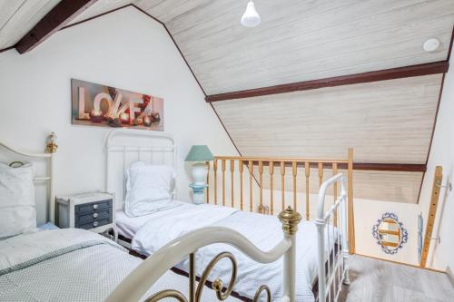 2 camas individuales en una habitación con techo en Gite Barbey, en Sainte-Marie-du-Mont