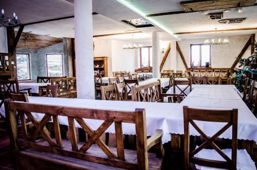a dining room with a white table and wooden chairs at Dwa Dęby in Lubawka