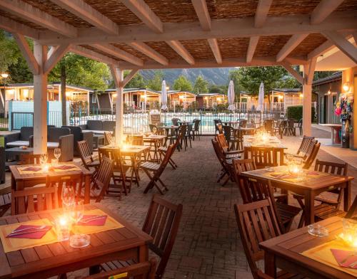 un restaurante al aire libre con mesas y sillas de madera en Il Borgo delle Arti, en Verbania