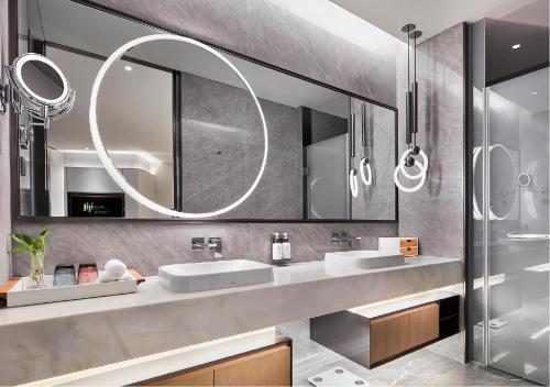 a bathroom with two sinks and a large mirror at EVEN Hotel Nanjing Yangtze River by IHG in Nanjing