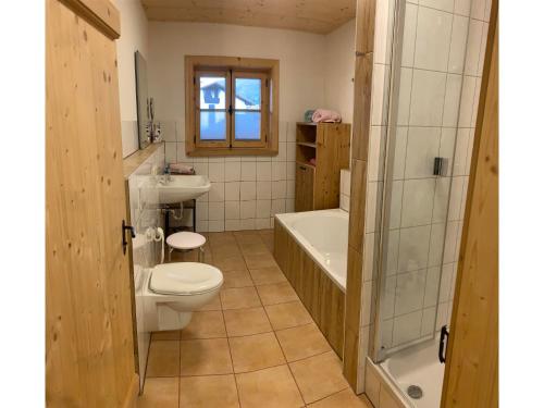 a bathroom with a toilet and a tub and a sink at Webergütl - Chiemgau Karte in Inzell