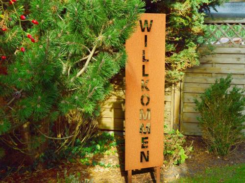 a sign in front of a christmas tree at Hotel Das kleine Glück - Adults Only in Sankt Peter-Ording