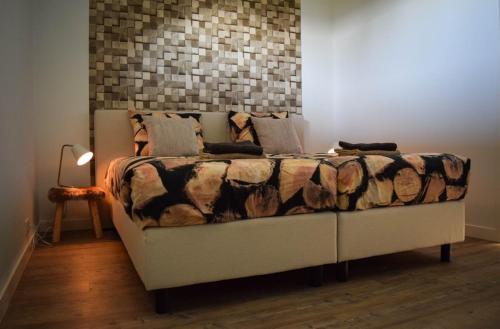 a bed with a comforter and pillows in a room at Roggebroek 13 in Stavoren