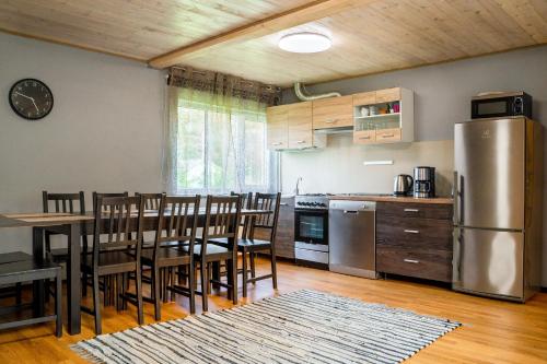 a kitchen with a table and chairs and a refrigerator at Metsaääre Accommodation in Uulu