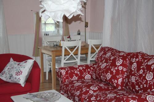 a living room with a red couch and a table at Ferienhof Spiegelhaus in Krummhörn