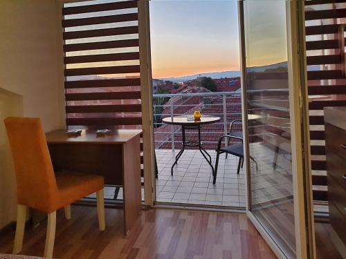 a room with a balcony with a table and a desk at Sky Apartments in Strumica