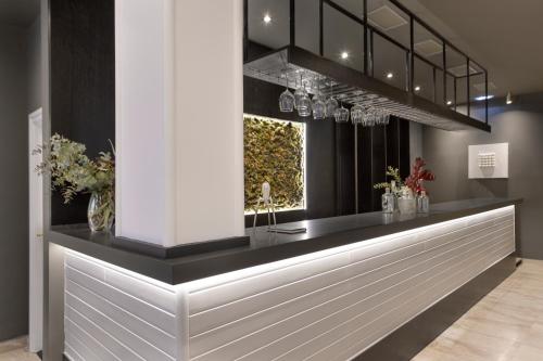 a lobby with a counter with flowers and a window at Hotel Inca in Zaragoza