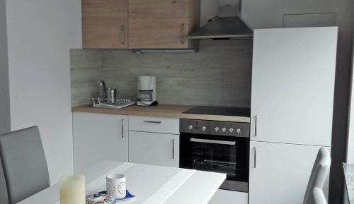a kitchen with a stove and a refrigerator and a table at PR`Cajhn in Radovljica