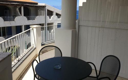 una mesa azul y sillas en el balcón en Hotel Cutimare - Aeolian Charme en Acquacalda