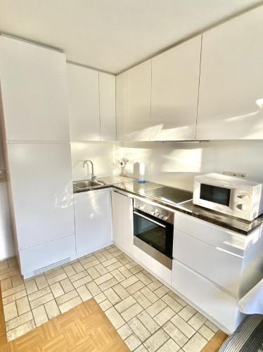 a white kitchen with a sink and a microwave at Ferienwohnungen Anna Altmann in Furth im Wald