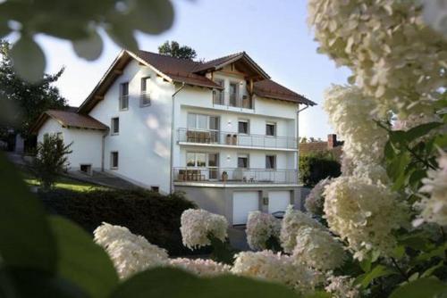 a white house with flowers in front of it at Ferienwohnungen Anna Altmann in Furth im Wald