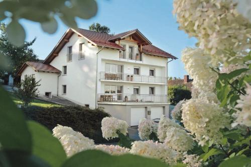 een wit huis met bloemen ervoor bij Ferienwohnungen Anna Altmann in Furth im Wald