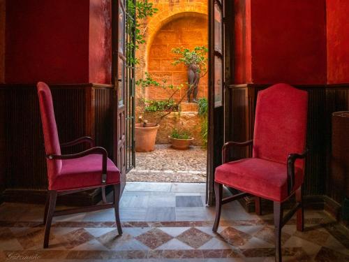 an empty room with red walls and a red chair at Palacio Marques de la Gomera in Osuna