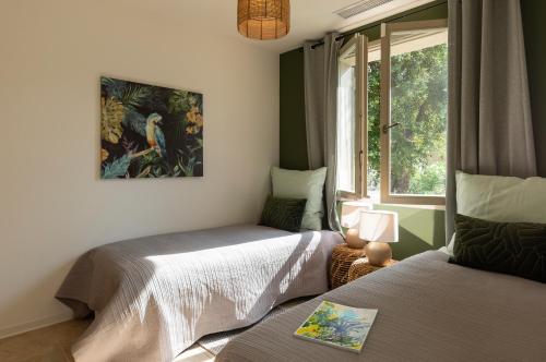 une chambre avec deux lits et une fenêtre dans l'établissement Villa Air et Mer, à Saint-Tropez