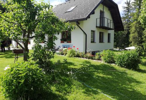 a small white house with a grass yard at PR`Cajhn in Radovljica