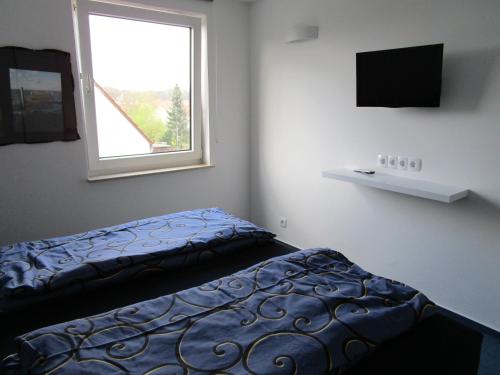 een slaapkamer met een bed en een raam bij Bed & Breakfast Wunstorf in Wunstorf