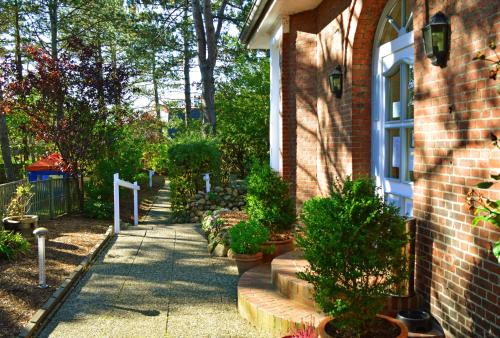 a garden with potted plants and a brick house at Hotel kleine Auszeit - Adults Only in Sankt Peter-Ording
