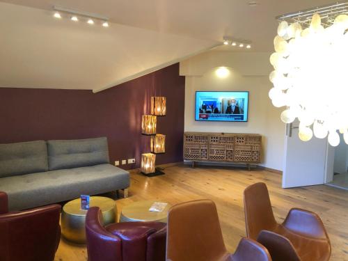 a living room with a couch and a tv at Landhaus Kössel in Füssen