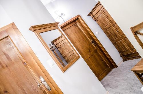 a hallway with wooden doors and a mirror at Dwa Dęby in Lubawka