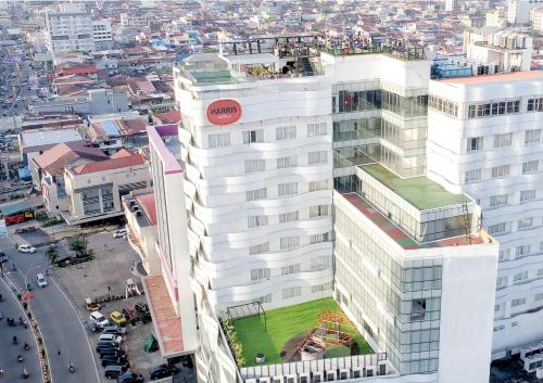 an aerial view of a tall white building with a green lawn at HARRIS Hotel Pontianak in Pontianak