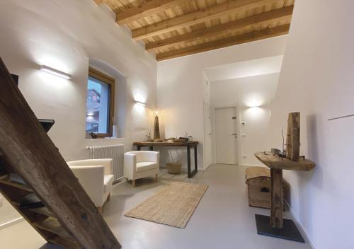 Elle comprend un salon doté de murs blancs et de plafonds en bois. dans l'établissement agriturismo farmhouse la barberina, à Calceranica al Lago