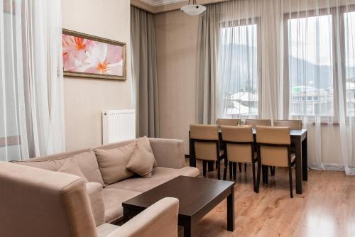 a living room with a couch and a table and chairs at Apartments in Gorki Gorod in Estosadok