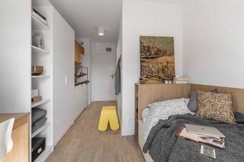 a small bedroom with a bed with a laptop on it at Apartamenty Depot Gdańsk in Gdańsk