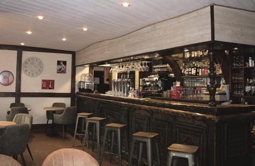 un bar en un restaurante con taburetes en Hotel Au Bout Du Monde, en Le Conquet