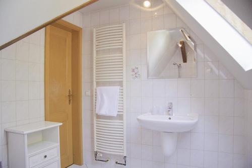 a white bathroom with a sink and a shower at Gasthof Schloss Hubertus in Erfurt