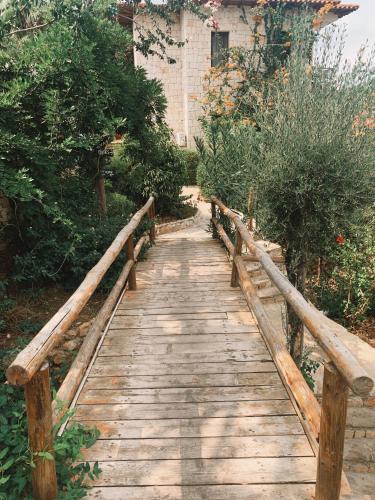 a wooden walkway in a garden with a building at Club Hotel Barbarossa in Kas