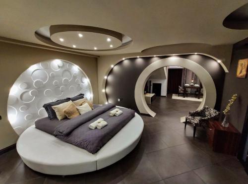 a bedroom with a large bed and a round mirror at Sky Apartments Special in Strumica