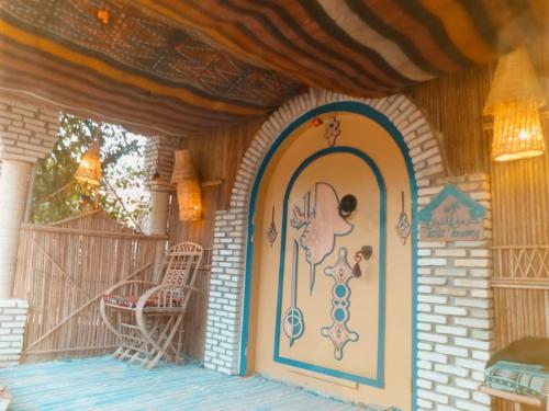 a front door of a house with a chair on a porch at Tente et Restaurant ElBey in Douz
