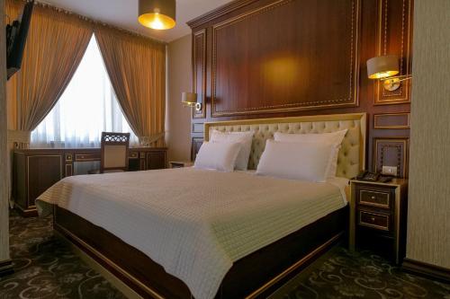um quarto com uma cama grande e uma janela grande em Rozafa Hotel em Shkodër