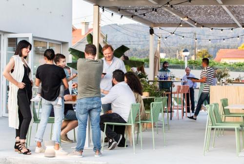 a group of people standing outside of a restaurant at Apartamentos Dena in Coirón