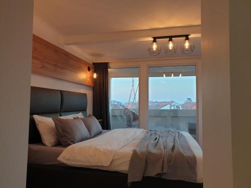 a bedroom with a bed with a large window at Sky Apartments Special in Strumica
