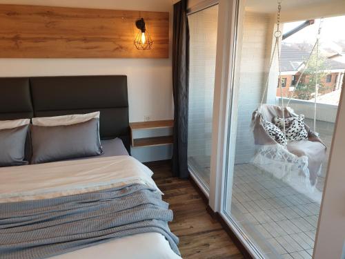 a bedroom with a bed and a balcony with a swing at Sky Apartments Special in Strumica