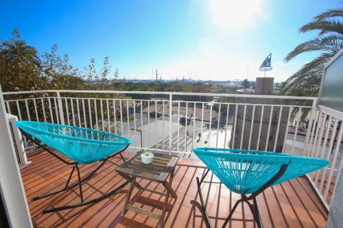 a balcony with two blue chairs and a table at Solvi Hotel - Adults Only in Vilanova i la Geltrú
