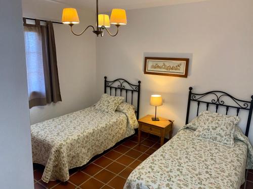 a bedroom with two beds and a lamp on a tiled floor at Casas Tomare I in San Bartolomé