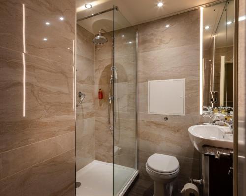 a bathroom with a shower and a toilet and a sink at Cassidys Hotel in Dublin