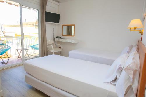 Solvi Hotel - Adults Only في فيلانوفا إ لا غيلترو: غرفه فندقيه بسرير وشرفه