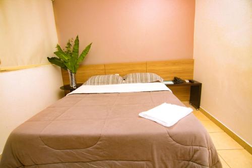 a bedroom with a large bed in a room at Hotel Alpha in Uberlândia
