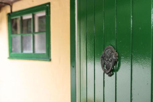 a green door and a window on a building at Sandet in Borre