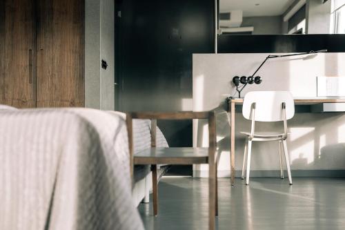 a bedroom with a table and a chair and a desk at Asgard Hotel in Groningen