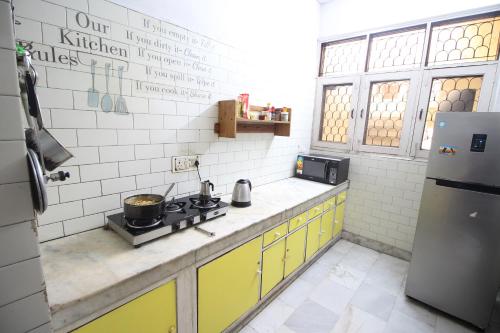 a small kitchen with a stove and yellow cabinets at The Desire Hostel in New Delhi