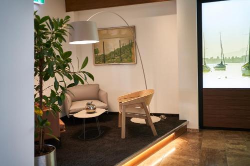 a living room with a chair and a table at Hotel City Krone in Friedrichshafen