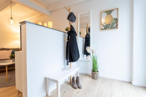a room with a white wall with a sliding door and a table at Weberhof Ferienapartments in Rostrup am Westufer des Zwischenahner Meers in Bad Zwischenahn